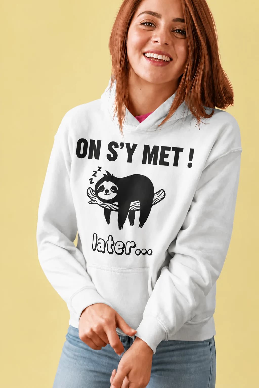 Sweat à capuche blanc porté par une femme, paresseux endormi sur une branche entre « On s'y met ! » et « plus tard… »