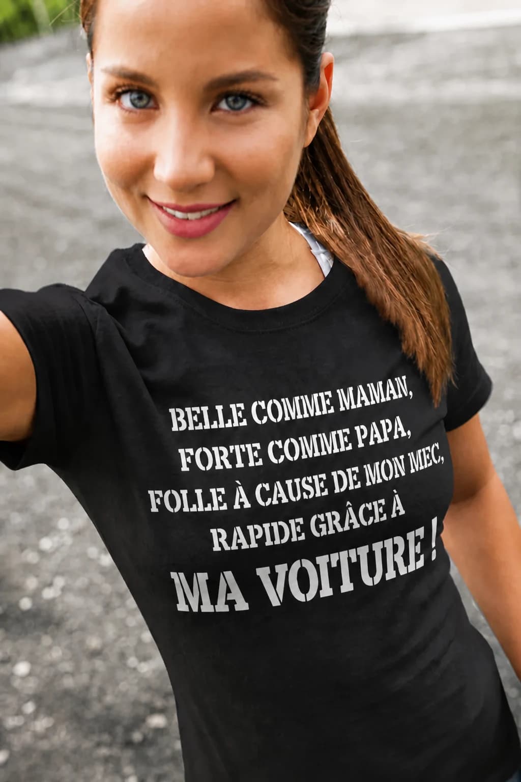 Jeune femme en t-shirt noir « Belle comme maman, forte comme papa, folle à cause de mon mec, rapide grâce à… »
