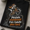 T-shirt vélo humoristique avec vélo dessiné en mouvement, slogan Pédale maintenant. Fais l’adulte plus tard. en orange et blanc sur fond sombre